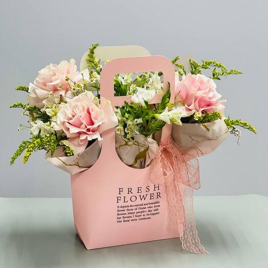 Bouquet of pink French roses with alstroemeria in a handbag