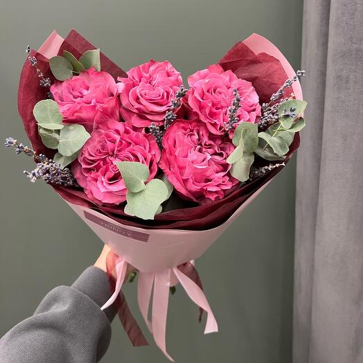 A compliment of a peony-shaped rose with sprigs of lavender and eucalyptus