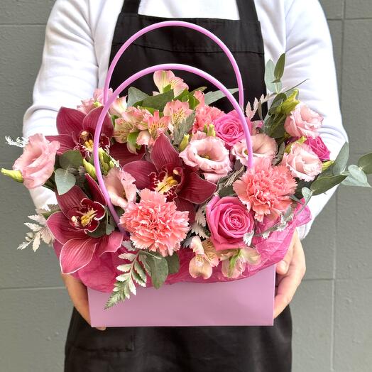 A composition in a handbag with orchids