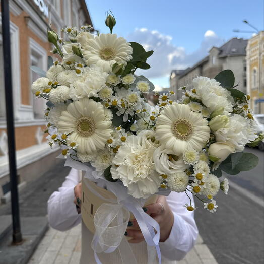 Белоснежная композиция в шляпной коробке со стойкими герберами, полевыми ромашками, ажурными диантусами, ароматной хризантемой
