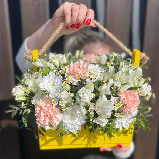 A composition of warm tones in a box with daisies and alstroemeria