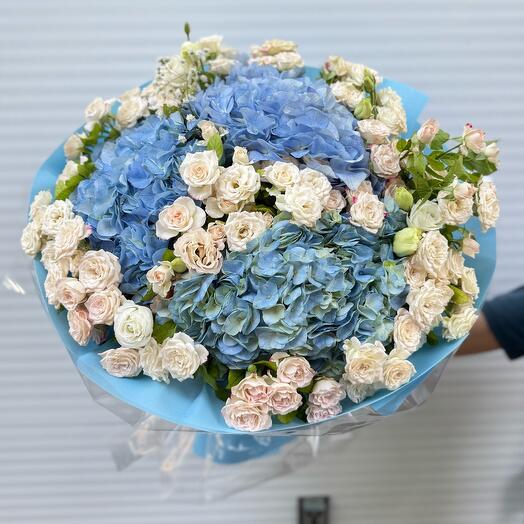 Bouquet of blue hydrangeas and spray of roses