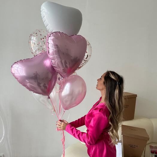 An armful of balloons, ordinary and foil hearts