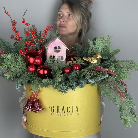 Новогодняя композиция в большой золотой коробке из ароматного нобилиса, илекса и туи, украшенная яркими блестящими игрушками