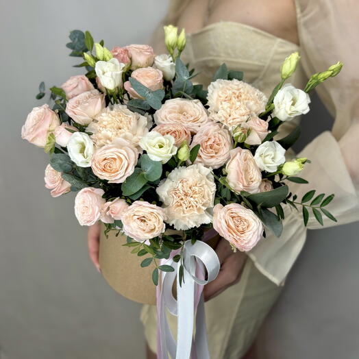 Composition in a peach-colored box of peony-shaped roses and eustoma
