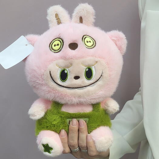 Розовая игрушка в зеленой кофте