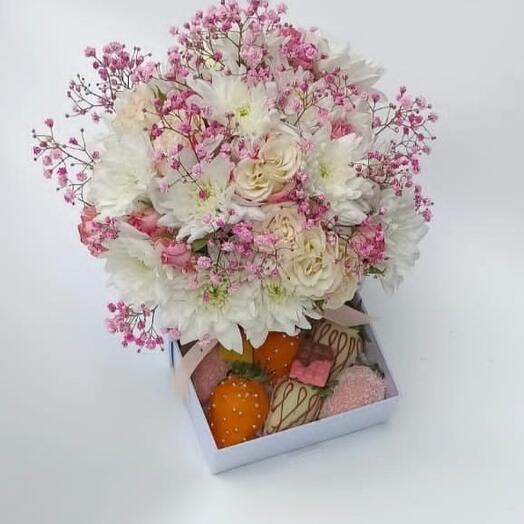 Caja con flores frescas y fresas cubiertas de chocolate.