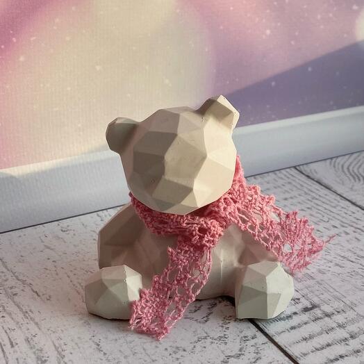 Oso de peluche blanco de hormigón con bufanda rosa