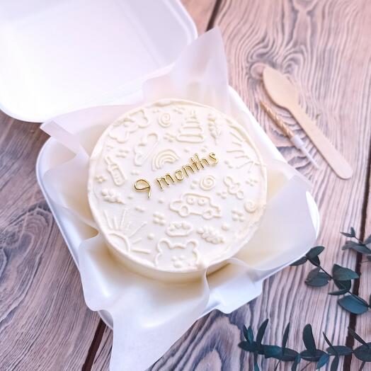 Pastel de Bento mensual con dibujos para niños y letras doradas