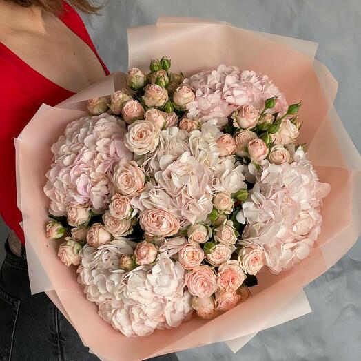 Bouquet of peony-shaped roses with hydrangeas in bed colors as a gift