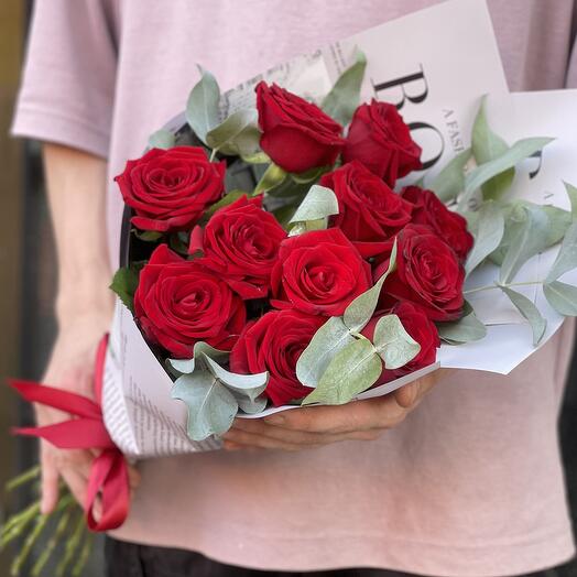 Eleven maroon roses with eucalyptus in newspaper wrapping
