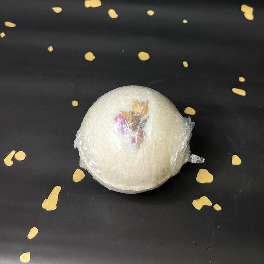 A bath bomb with dried rose flowers