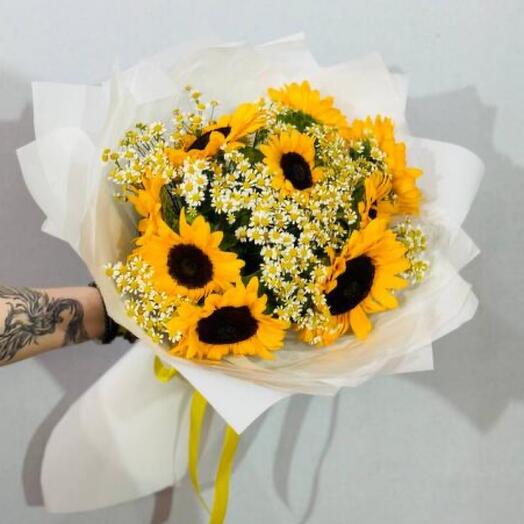 A bouquet of sunflower flowers with wild daisies in a bouquet