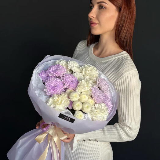 Букет из сиренево-белых кустовых хризантем, хризантемы Сантини и гвоздик в лавандовой упаковке