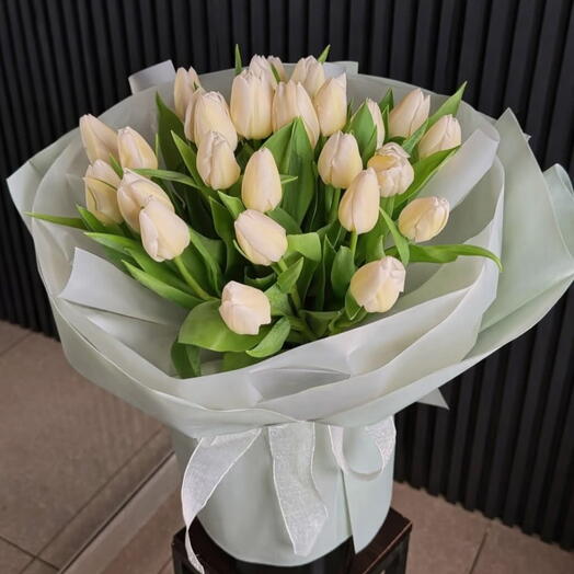 Красивый букет белых тюльпанов в упаковке