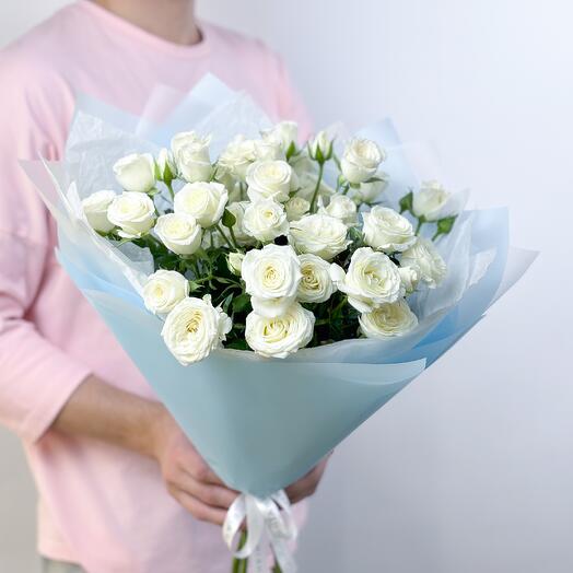 Delicate bouquet of white bush roses in a blue package