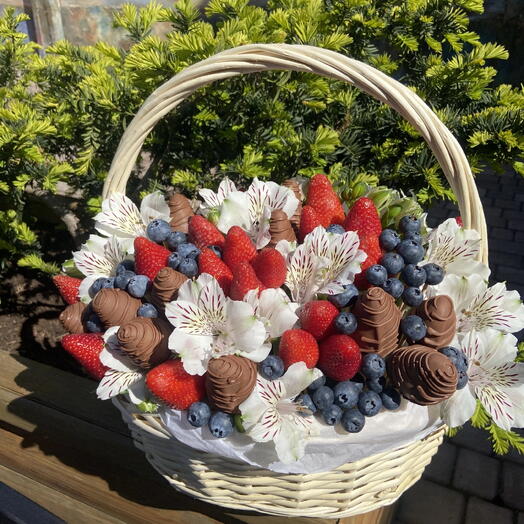 Cesta de flores, fresas cubiertas de chocolate y bayas frescas