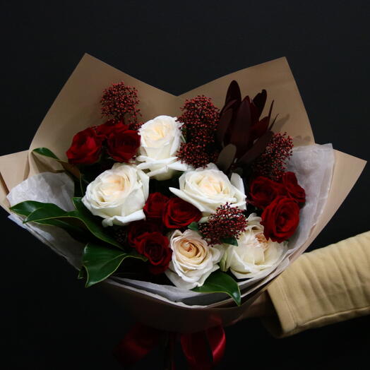 Bouquet with peony roses, red roses, leucodendron and skimmia