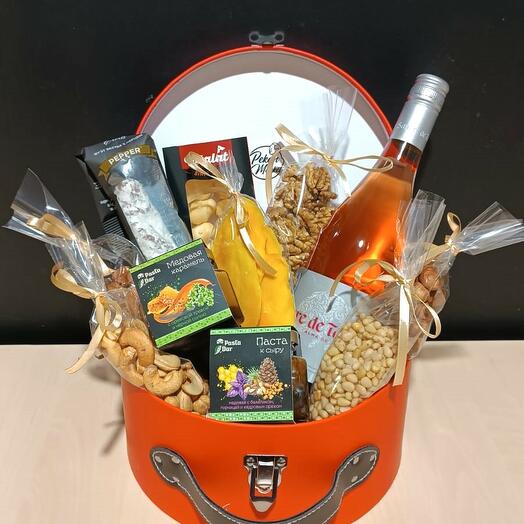 A gift set of various types of cheese with nuts, dried fruits and non-alcoholic wine