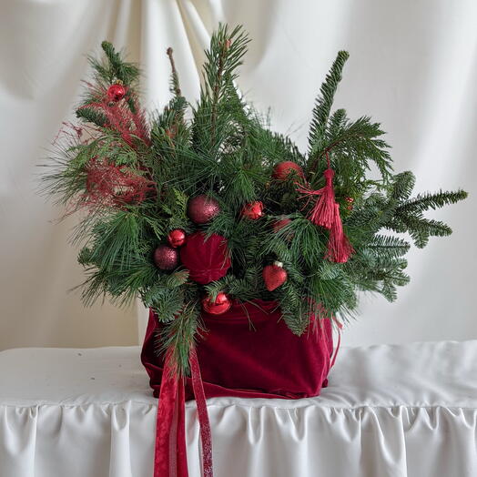 Композиция новогодняя из разных сортов хвои с игрушками в красном бархатном мешочке