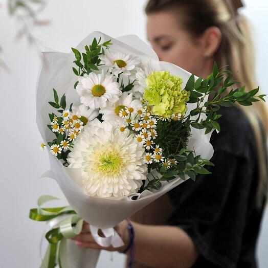 Элегантный букет из белых хризантем, ромашек и зелени, перевязанный зелёной лентой