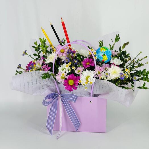 A handbag with flowers, a globe and colored pencils