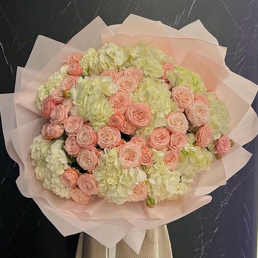 A large delicate bouquet with hydrangeas and a bushy peony-shaped rose