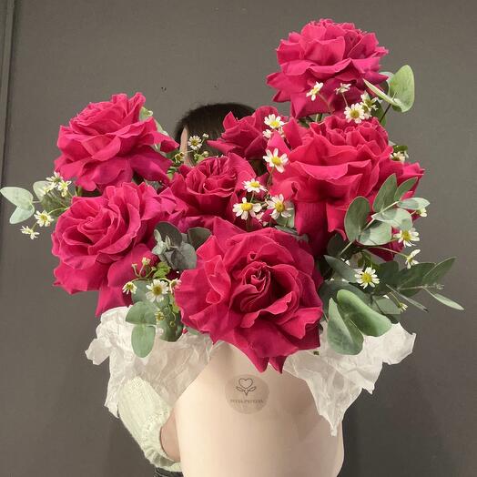 Bright pink roses, chamomile and eucalyptus in a box