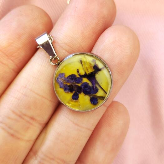 A pendant with real flowers on yellow background