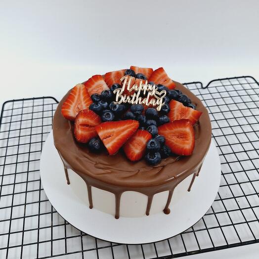 A cake with berry decoration, streaks and a topper