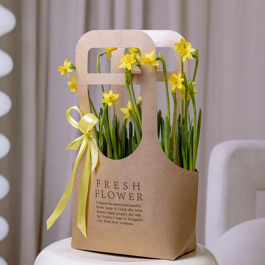 A composition of daffodils in a handbag