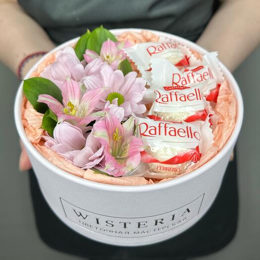 Fresh flowers and sweets in a round box