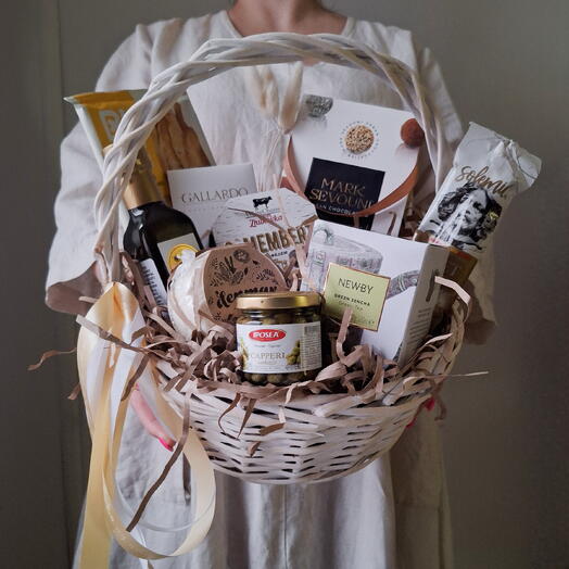 Песочно-золотая продуктовая корзина. Чай, масло, конфеты, каперсы, сыр, колбаса, шоколад и хлебные палочки