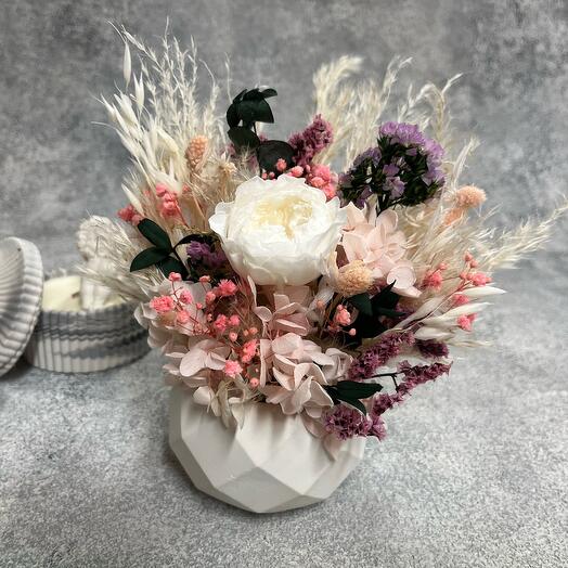 Bouquet of dried flowers in a planter with a rose