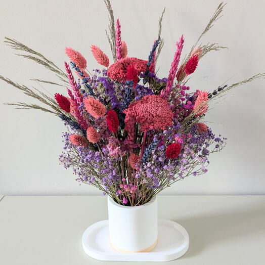 Centro de mesa con flores lilas y rojas