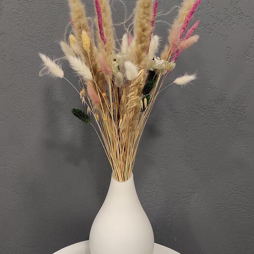 Interior composition of dried flowers in a white glass vase
