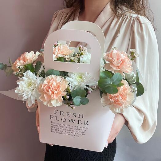 Bush chrysanthemums and delicate dianthuses in a stylish handbag