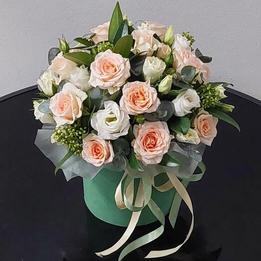 Flowers in a box. Bush roses, eustoma and skimmia in a hat box