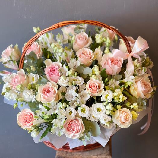 Delicate bouquet of pink roses, white eustoma and alstroemeria in a basket