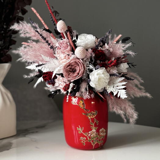 Яркая интерьерная настольная композиция с нежными пионами и жгучими розами в стильной вазе