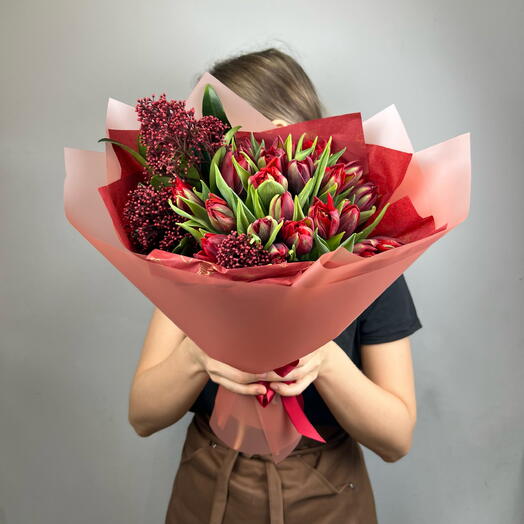 Страстный букет из красных пионовидных тюльпанов и скиммии