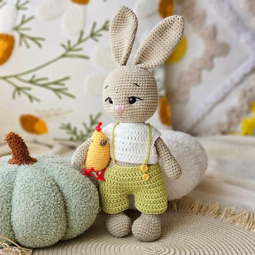 A knitted rabbit with a chicken is a handmade toy