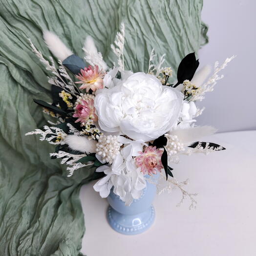 Bouquet of dried flowers with a peony rose in a vase