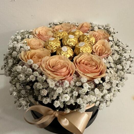 Flowers in a black round box with chocolates