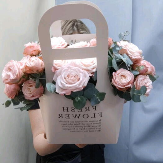 Flowers in a handbag made of bushy peony-shaped roses and eucalyptus