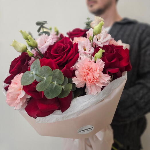 Воздушный яркий букетс красными розами, нежной эустомой в пышной стильной упаковке
