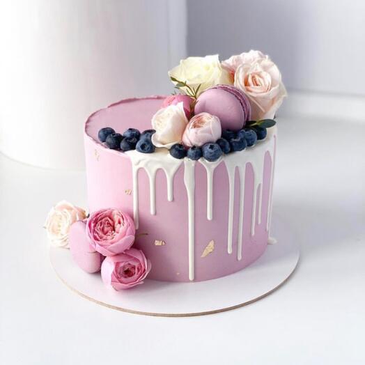 Cake with edible flowers, macaroons and blueberries