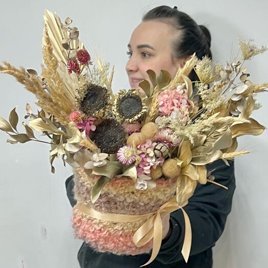 Composition of dried flowers with sunflower, hydrangea, helichrysum, craspedia, columns, palm leaf with greenery in a planter